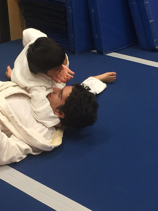 Instructor demonstrating a jujitsu throw with a student at a member dojo.
